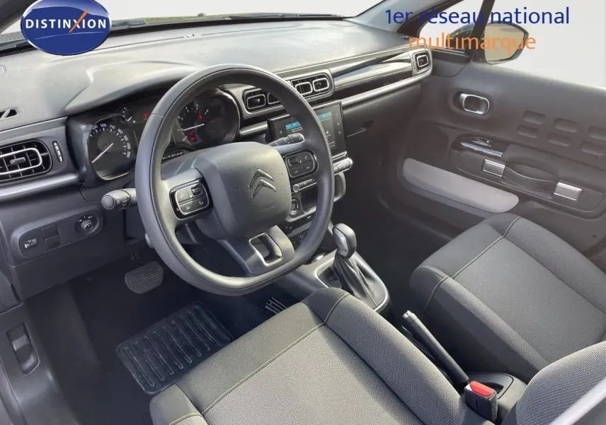 Intérieur avant d'une Citroën C3 2023, vue côté conducteur, volant multifonction et sellerie tissu gris noir.