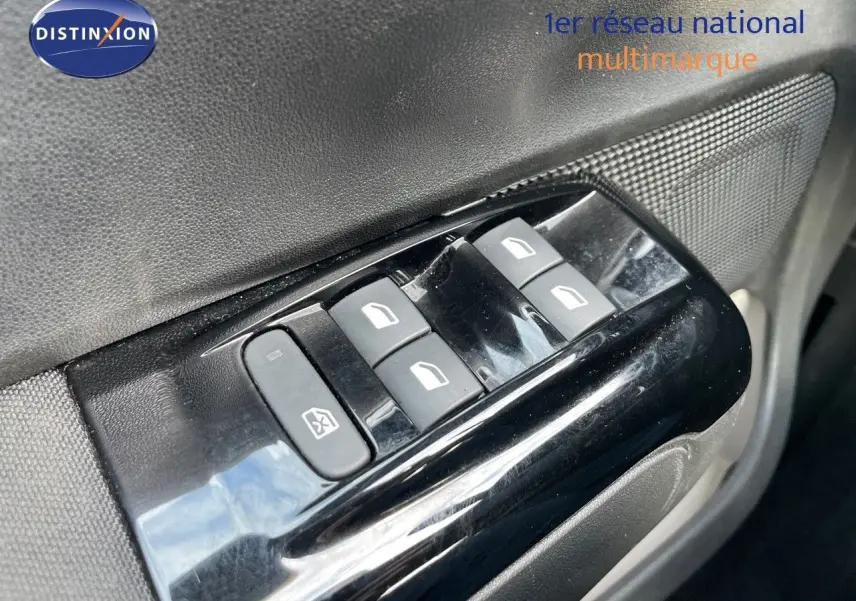 Gros plan sur les commandes des vitres électriques côté conducteur de la Citroën C3 gris platinium métal 2023.