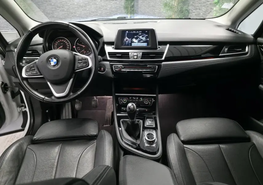Intérieur noir cuir de la BMW Série 2 Gran Tourer 218d, vue frontale du tableau de bord et volant multifonctions.