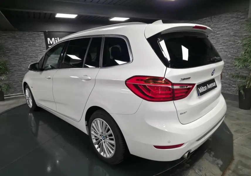 Vue 3/4 arrière droite d'une BMW Série 2 Gran Tourer blanche avec jantes alliage et feux arrière LED distinctifs.