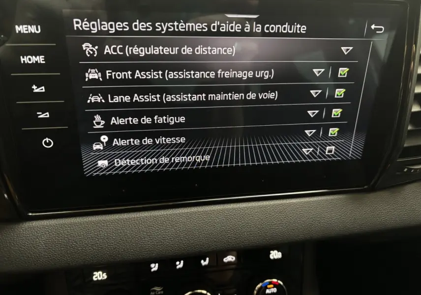 Écran tactile central du Skoda Karoq 2025 affichant les réglages des aides à la conduite dans un intérieur noir.