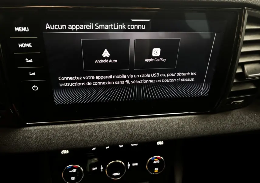 Écran tactile central affichant la connexion Android Auto et Apple CarPlay dans le tableau de bord noir du Skoda Karoq 2025.