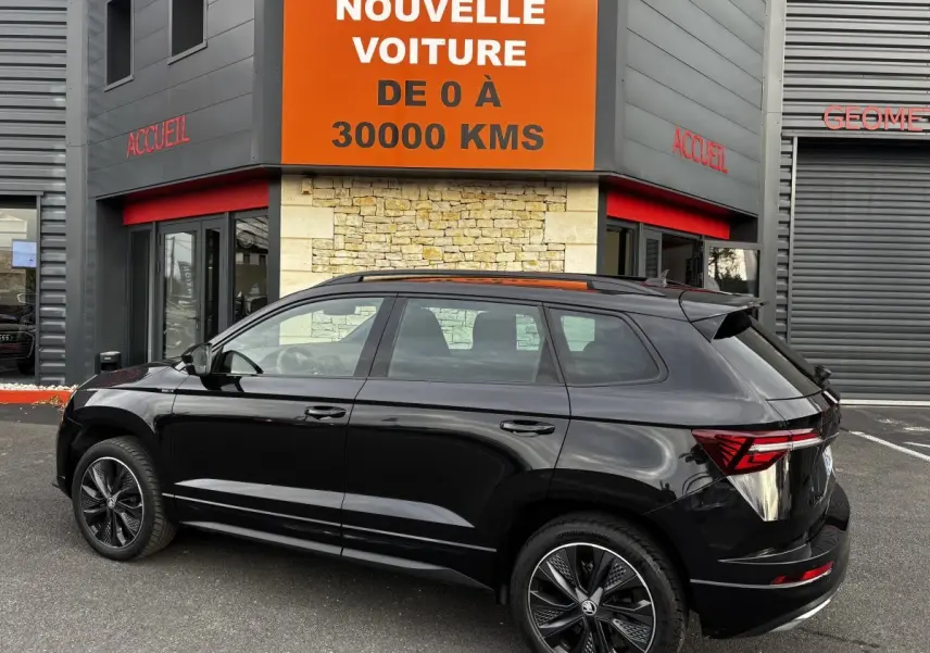 Vue latérale droite d'un SKODA KAROQ noir 2025 avec jantes alliage et feux arrière LED distinctifs.