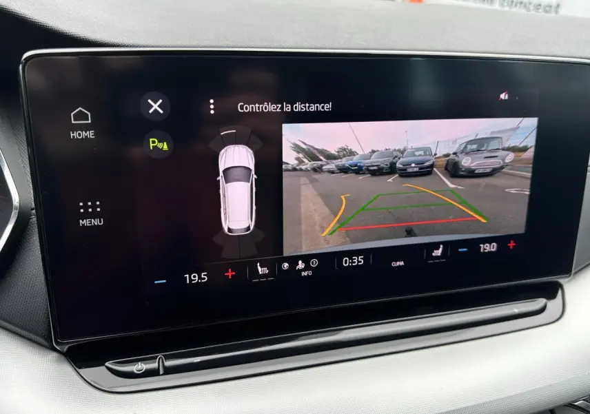 Écran central de la Skoda Octavia Combi gris graphite montrant la caméra de recul et l'aide au stationnement.