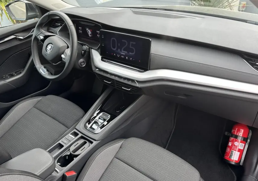Vue intérieure côté conducteur de la Skoda Octavia Combi 2024 avec tableau de bord noir et écran tactile central.