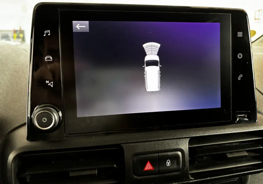 Écran tactile intérieur de l’Opel Combo 2021 affichant l’aide au stationnement avec vue du véhicule blanc en haut.