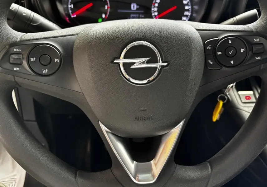 Gros plan sur le volant noir de l'Opel Combo 2021 avec commandes intégrées et logo central chromé.