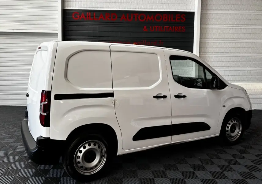 Vue de profil côté droit d'un utilitaire Opel Combo blanc avec portes latérales pleines et jantes acier.