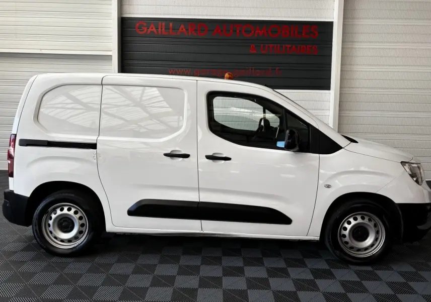 Profil côté gauche d'un utilitaire Opel Combo blanc 2021 avec porte latérale coulissante et jantes acier.