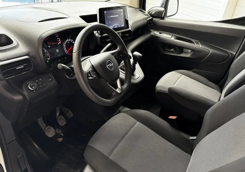 Intérieur noir et gris de l'Opel Combo 2021, vue côté conducteur montrant volant, tableau de bord et levier de vitesse manuel.