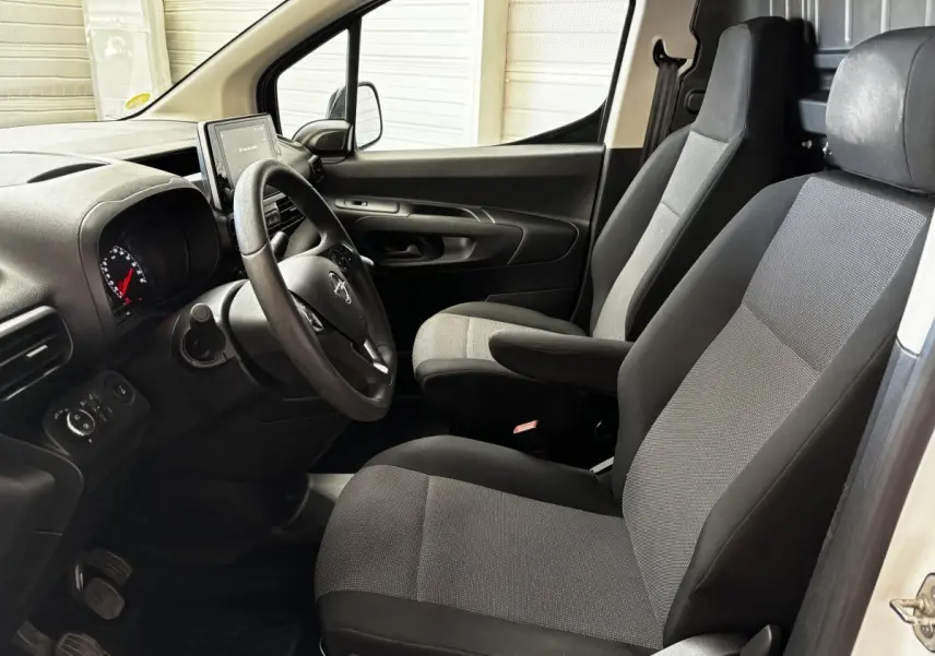 Intérieur avant droit de l'Opel Combo blanc 2021, montrant les sièges tissu gris et le tableau de bord avec écran tactile.