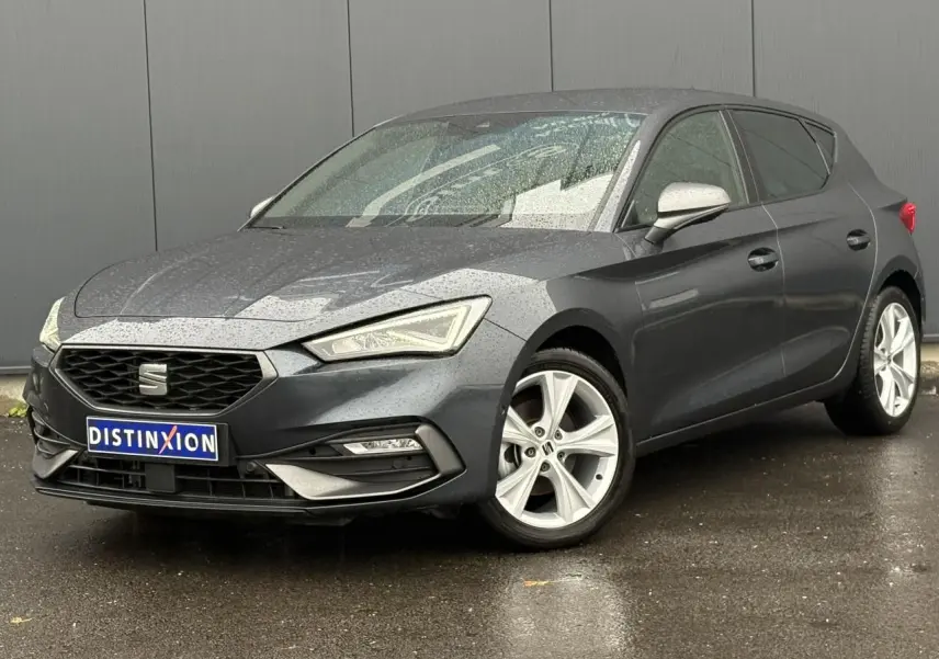 SEAT Leon 1.5 e-TSI 150 DSG7 FR gris magnétique vue 3/4 avant sous la pluie avec jantes alliage 17 pouces.