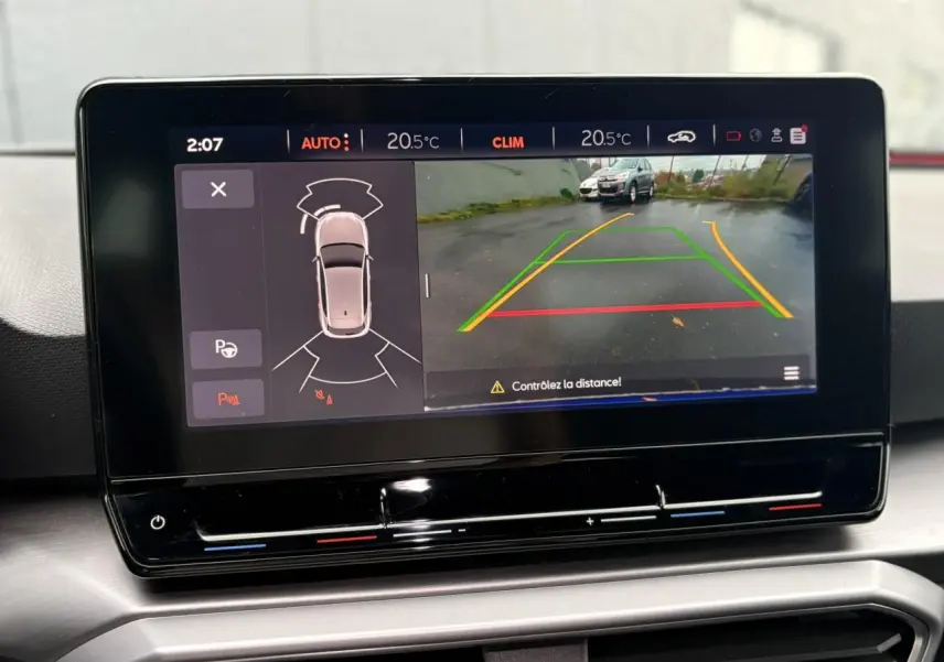 Écran tactile intérieur du SEAT Leon 2024 montrant la caméra de recul et l'aide au stationnement active.