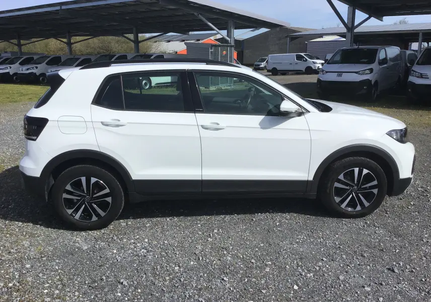 Vue de profil côté droit d'un Volkswagen T-Cross blanc 2021 avec jantes alliage noires et toit noir contrasté.