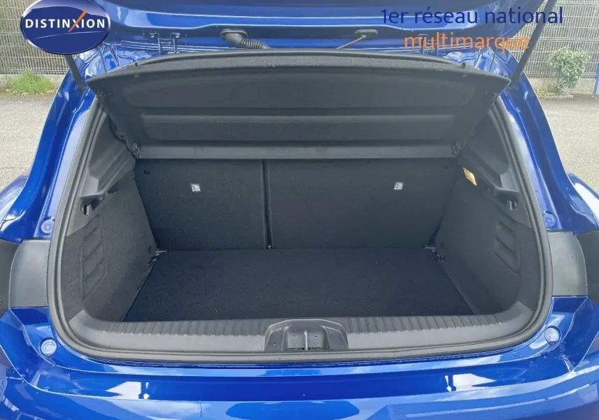 Coffre ouvert d'une Renault Clio TCe 90ch Techno bleu Iron Metal, vue arrière montrant l'espace de chargement vide.