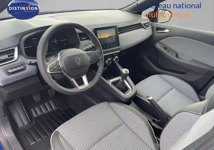 Vue intérieure côté conducteur de la Renault Clio TCe 90ch Techno 2025, avec tableau de bord moderne et sièges gris.