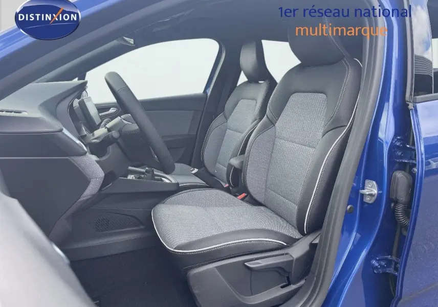 Vue intérieure côté conducteur d'une Renault Clio 2025 bleu Iron Metal avec sièges tissu gris et cuir noir.