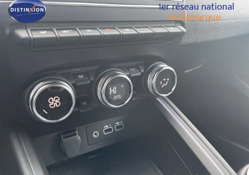 Gros plan sur les commandes de climatisation et prises USB de la Renault Clio TCE 90CH TECHNO bleu Iron Metal, intérieur moderne.