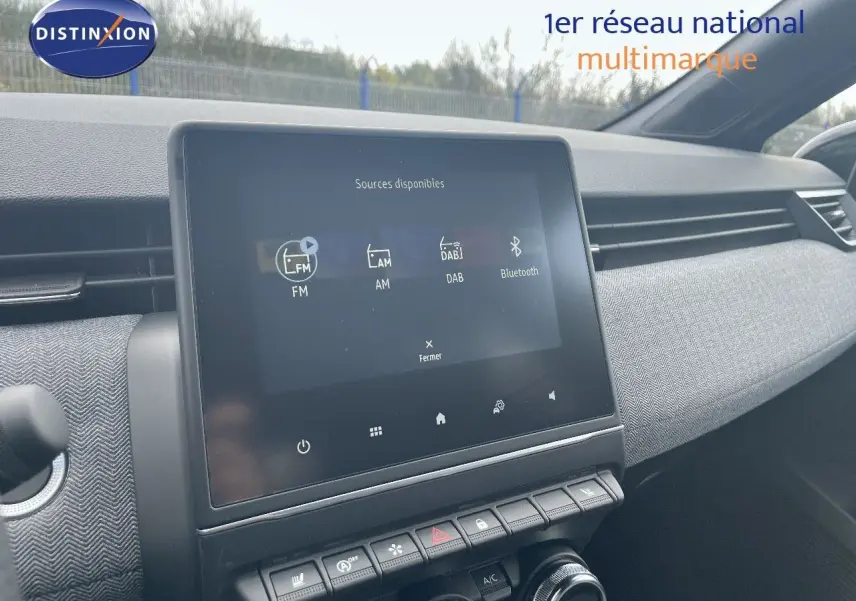 Vue intérieure du tableau de bord de la Renault Clio TCe 90ch Techno 2025 avec écran tactile et commandes de climatisation.