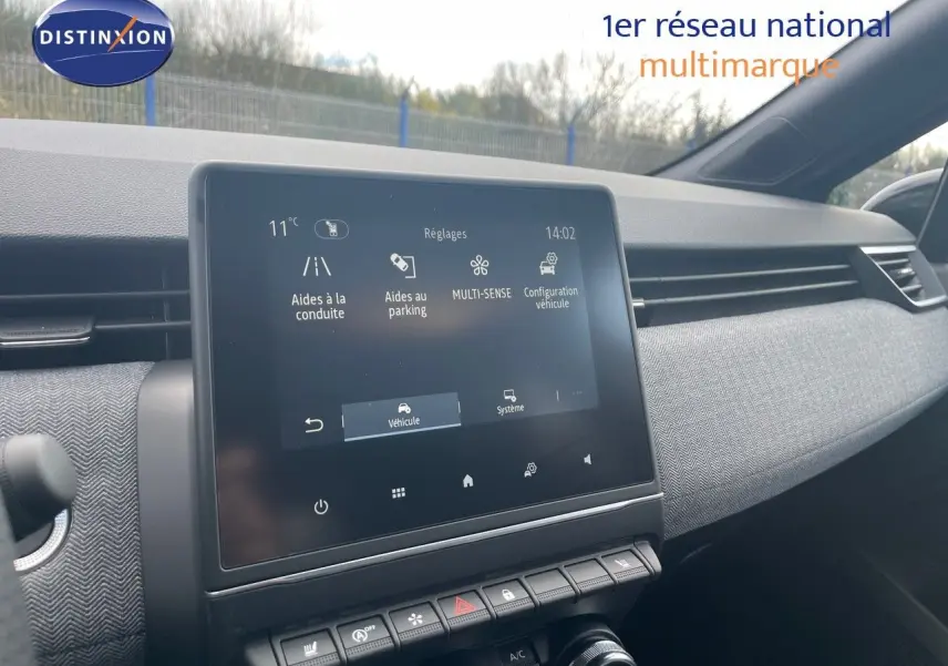 Vue intérieure du tableau de bord de la Renault Clio TCe 90ch Techno 2025 avec écran tactile et garniture tissu gris.