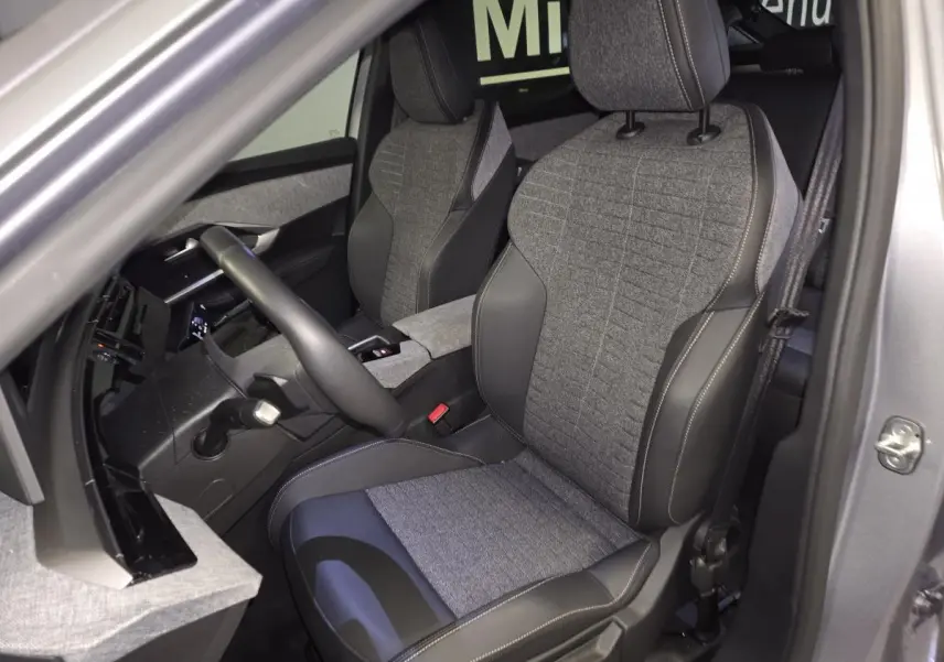 Vue intérieure côté gauche du Peugeot 3008 gris 2025, sièges tissu gris et cuir noir avec surpiqûres quartz.