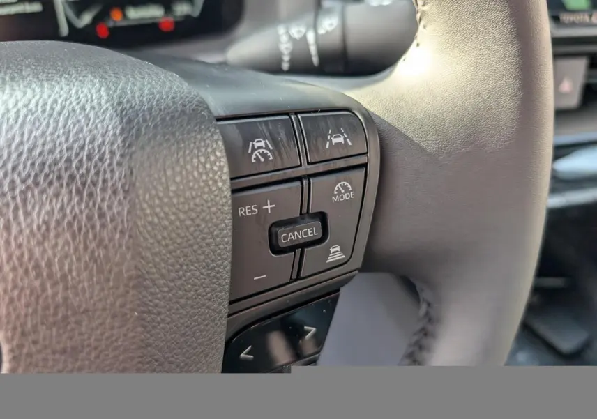 Gros plan sur les commandes du volant côté droit du Toyota C-HR 1.8 Hybrid blanc, boutons de régulateur et assistance.