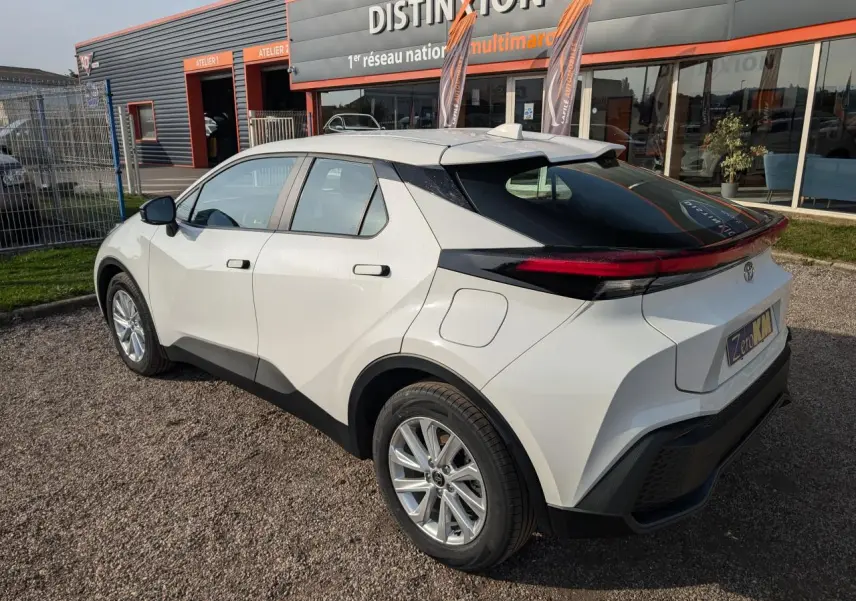 Vue 3/4 arrière droite d'un Toyota C-HR blanc 2024 avec feux arrière full LED et jantes alliage 17 pouces.