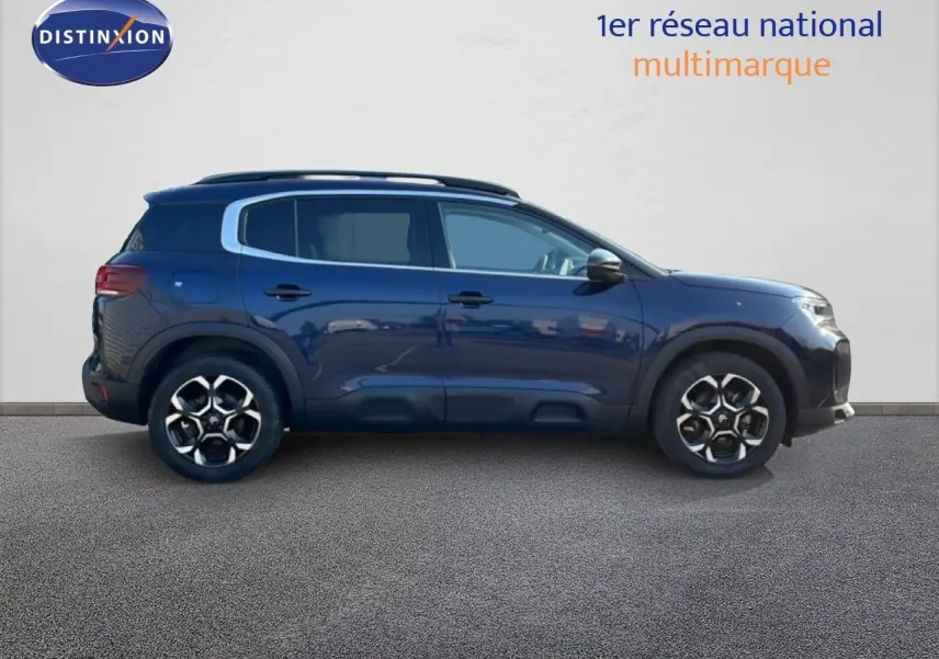 Profil droit du Citroën C5 Aircross 2025 bleu Eclipse Metal avec jantes bi-ton et barres de toit noires.