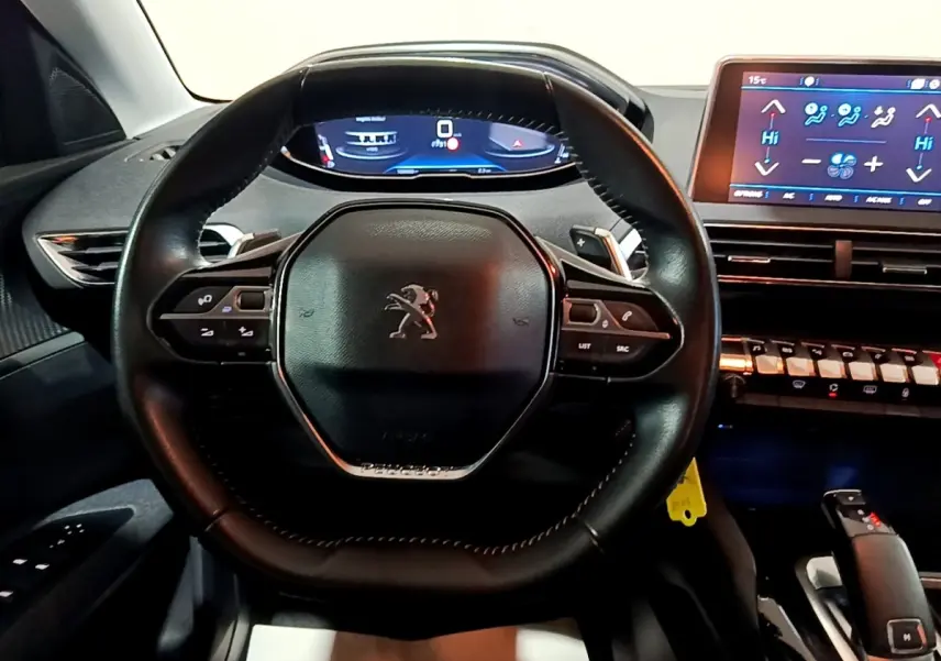 Vue rapprochée du volant cuir noir et du tableau de bord digital du Peugeot 5008 gris clair de 2020.