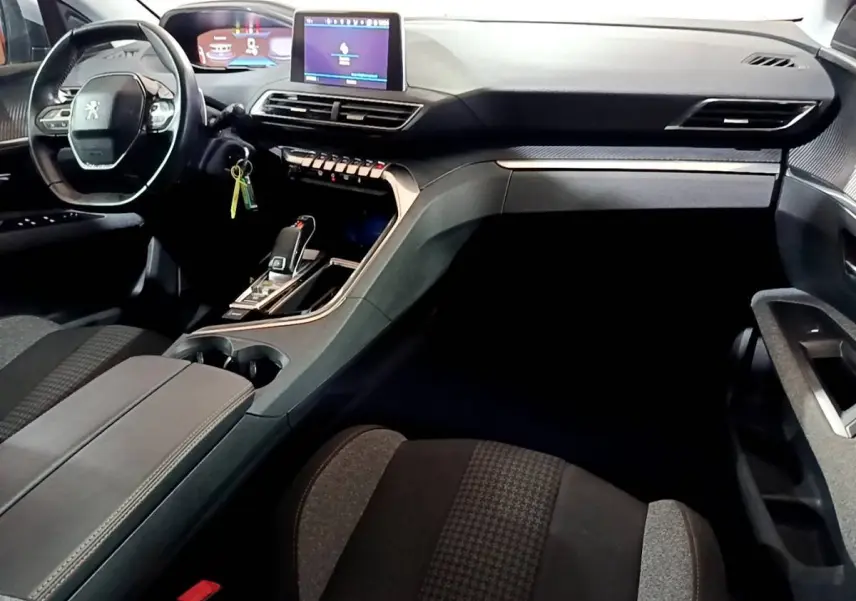 Vue intérieure côté conducteur du Peugeot 5008 2020, tableau de bord moderne avec écran tactile et volant cuir noir.