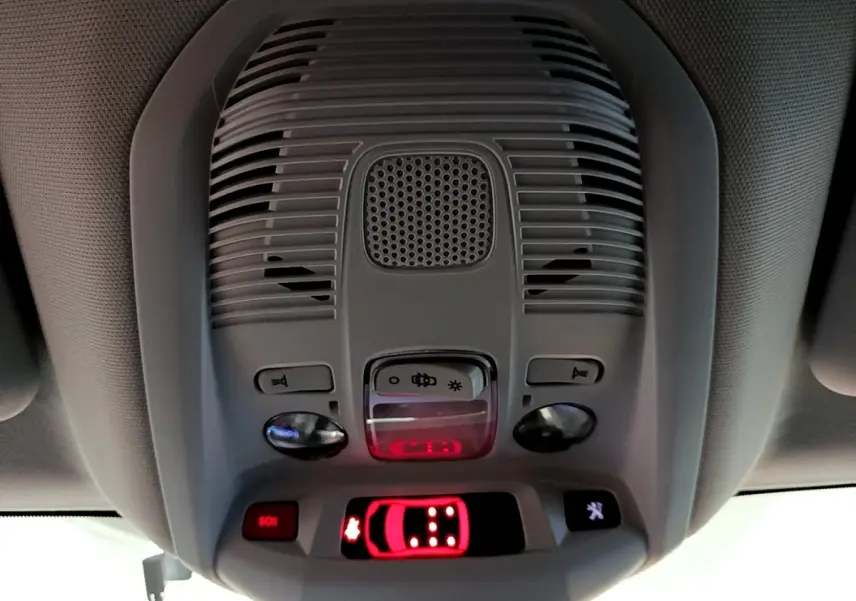 Vue en gros plan du plafonnier gris clair avec commandes et affichage lumineux rouge dans un Peugeot 5008 2020.