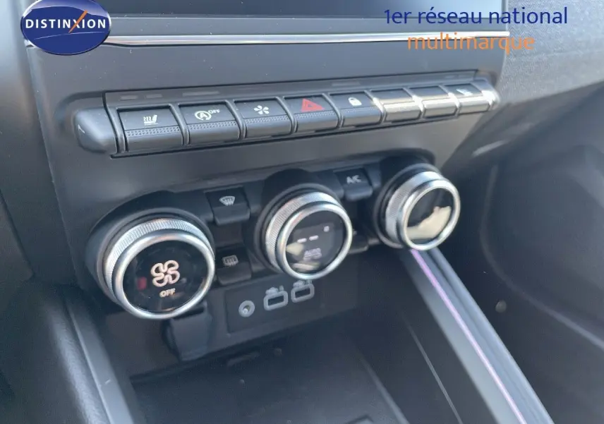 Gros plan sur les commandes de climatisation et les boutons de fonction du tableau de bord intérieur de la Renault Clio TCe 90ch Techno noire.