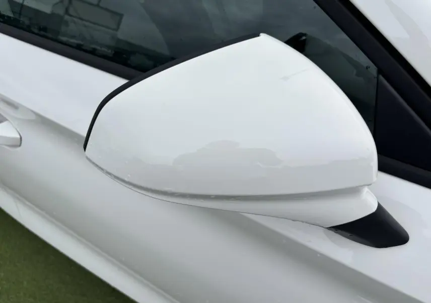 Rétroviseur côté gauche blanc brillant de la SEAT LEON IV 1.5 TSI 130CH STYLE PACK 2024 vue en gros plan.