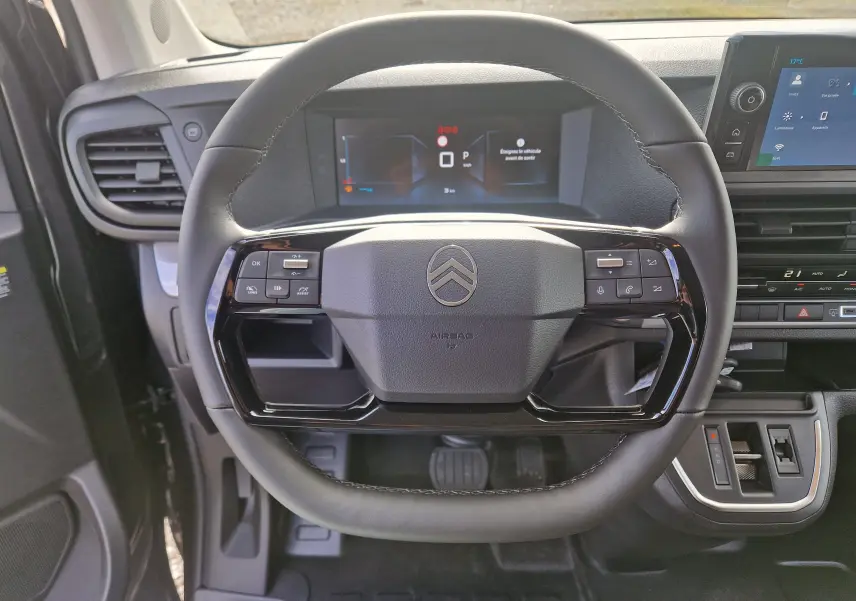 Vue rapprochée du volant cuir noir du Citroën Jumpy XL gris titane avec tableau de bord digital et commandes intégrées.