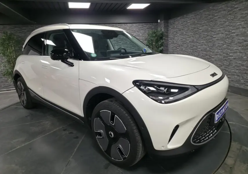 Vue 3/4 avant gauche d'une Smart #1 électrique blanche avec jantes noires et toit contrasté noir.