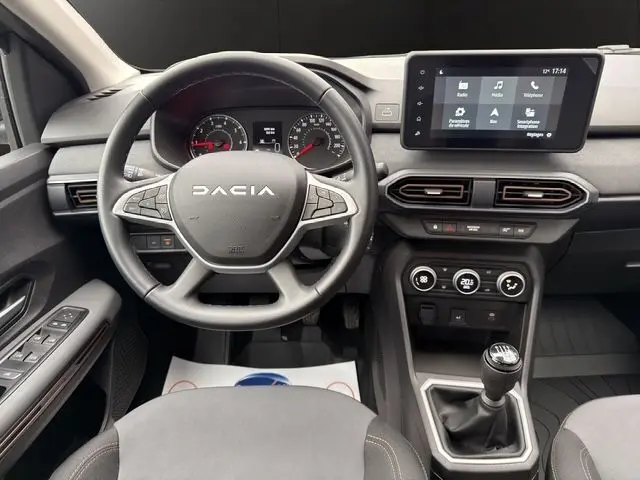 Vue intérieure centrée sur le volant DACIA et la console avec écran tactile de la Sandero Stepway 2025, boîte manuelle visible.