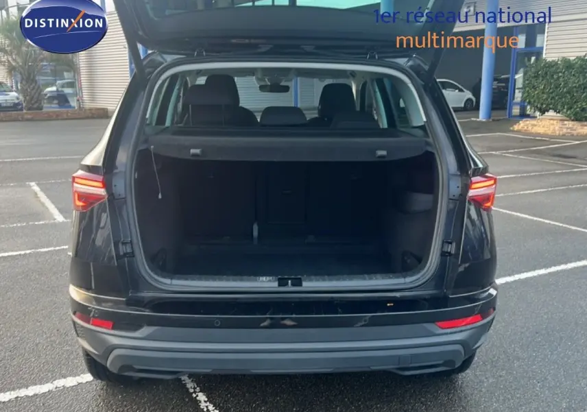 Vue arrière d'un Skoda Karoq noir Magic Metal avec coffre ouvert, mettant en valeur son espace de chargement.
