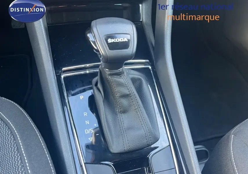 Le levier de vitesses automatique Skoda KAROQ 1.5 TSI noir, vue rapprochée de la console centrale intérieure.