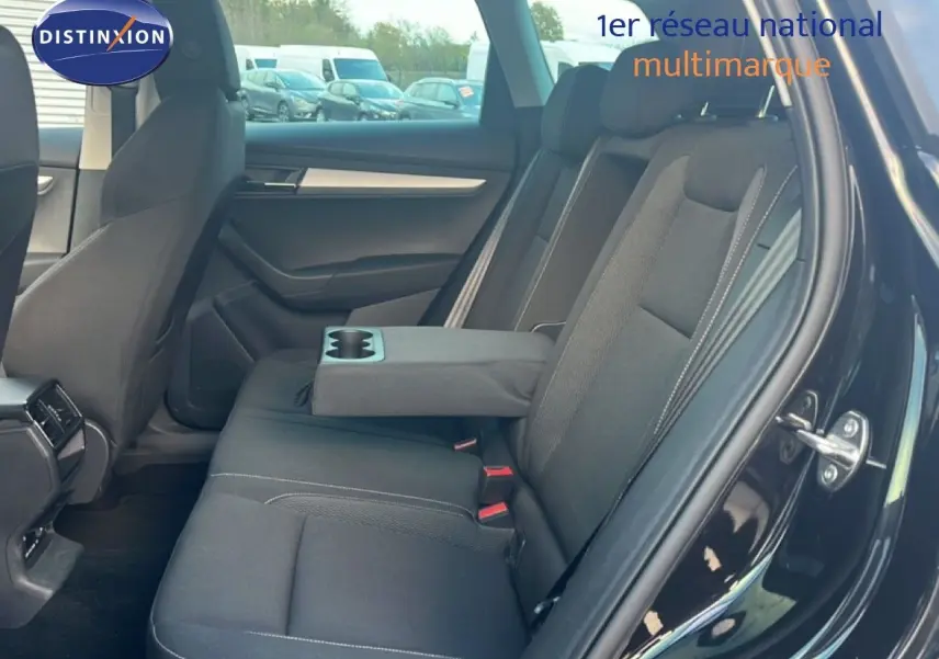 Intérieur arrière du Skoda Karoq noir Magic Metal, vue côté droit avec accoudoir central et porte ouverte.