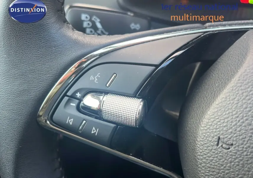 Gros plan sur les commandes audio au volant du Skoda Karoq 2023, finition Business, cuir noir et molette chromée.