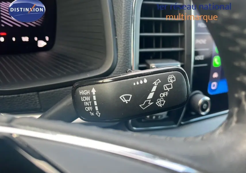 Gros plan sur la commande d'essuie-glace du Skoda Karoq noir Magic Metal, avec tableau de bord et écran tactile en arrière-plan.