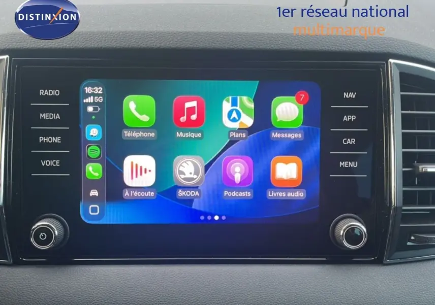 Écran tactile central du Skoda Karoq 2023 affichant les applications connectées, avec commandes autour en noir mat.