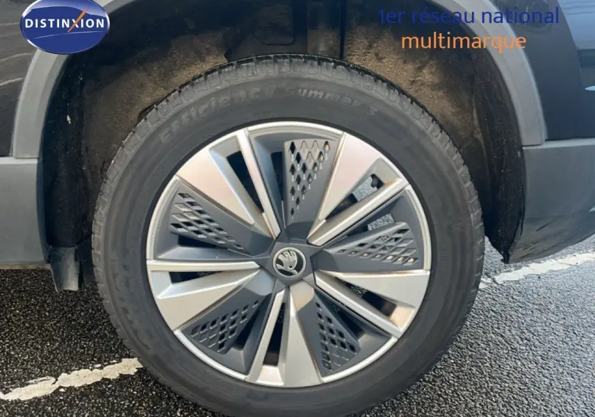 Gros plan sur la roue avant gauche d'un SKODA KAROQ noir Magic Metal avec jante alliage 17 pouces bicolore.