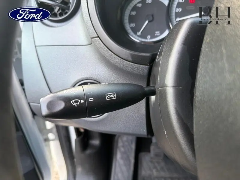 Gros plan sur la manette de commande d’essuie-glace à gauche du volant dans un Mercedes Citan blanc, vue intérieure côté conducteur.