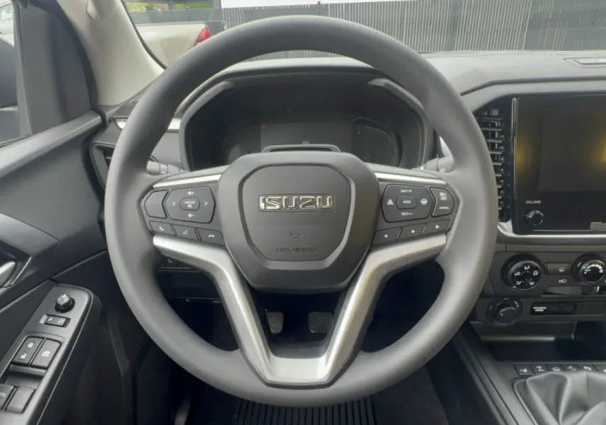 Vue centrée sur le volant multifonctions noir de l'Isuzu D-MAX 2026 avec tableau de bord et écran tactile.