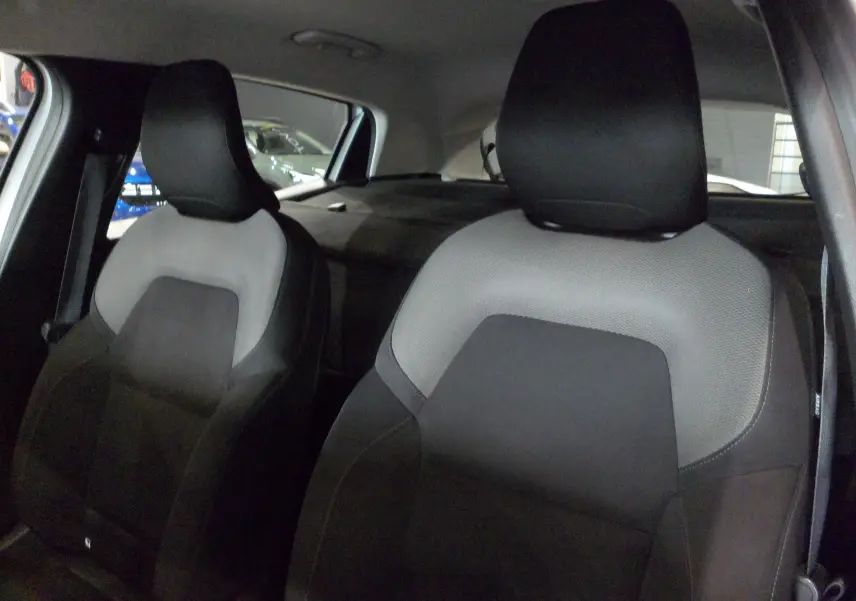 Gros plan sur les sièges avant en tissu gris et noir de la Renault Clio V Société Blanc Glacier, vue intérieure côté droit.