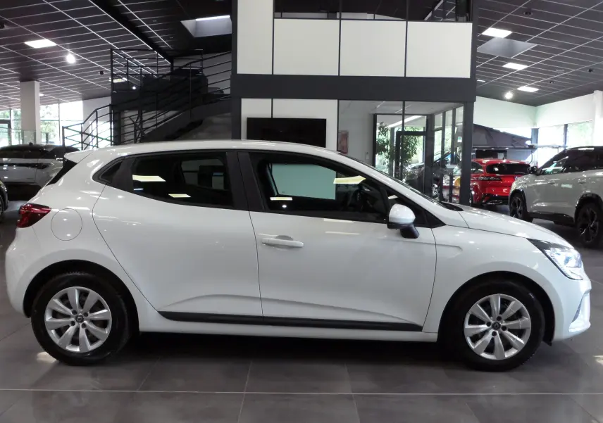 Profil côté gauche d'une Renault Clio V blanche Glacier en version Société, visible en intérieur showroom moderne.