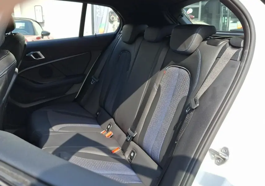 Vue intérieure sur les sièges arrière en tissu noir et bleu de la BMW Série 1 120i M Sport blanche de 2021.