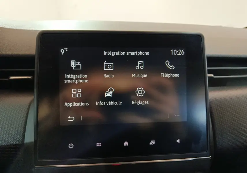 Écran tactile central de la Renault Clio gris clair 2023 affichant les options smartphone, radio, musique et téléphone.
