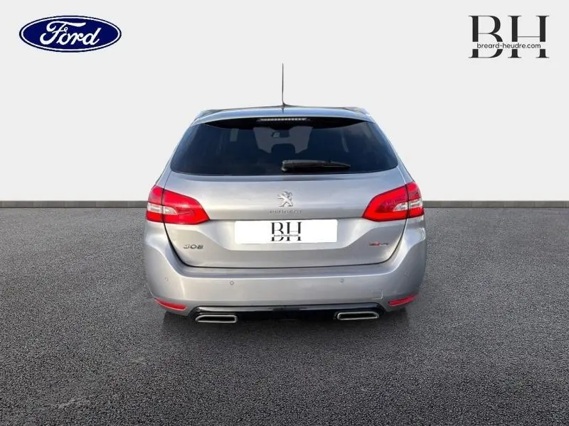 Vue arrière d'une Peugeot 308 SW gris Artense avec feux LED et double sortie d'échappement chromée.